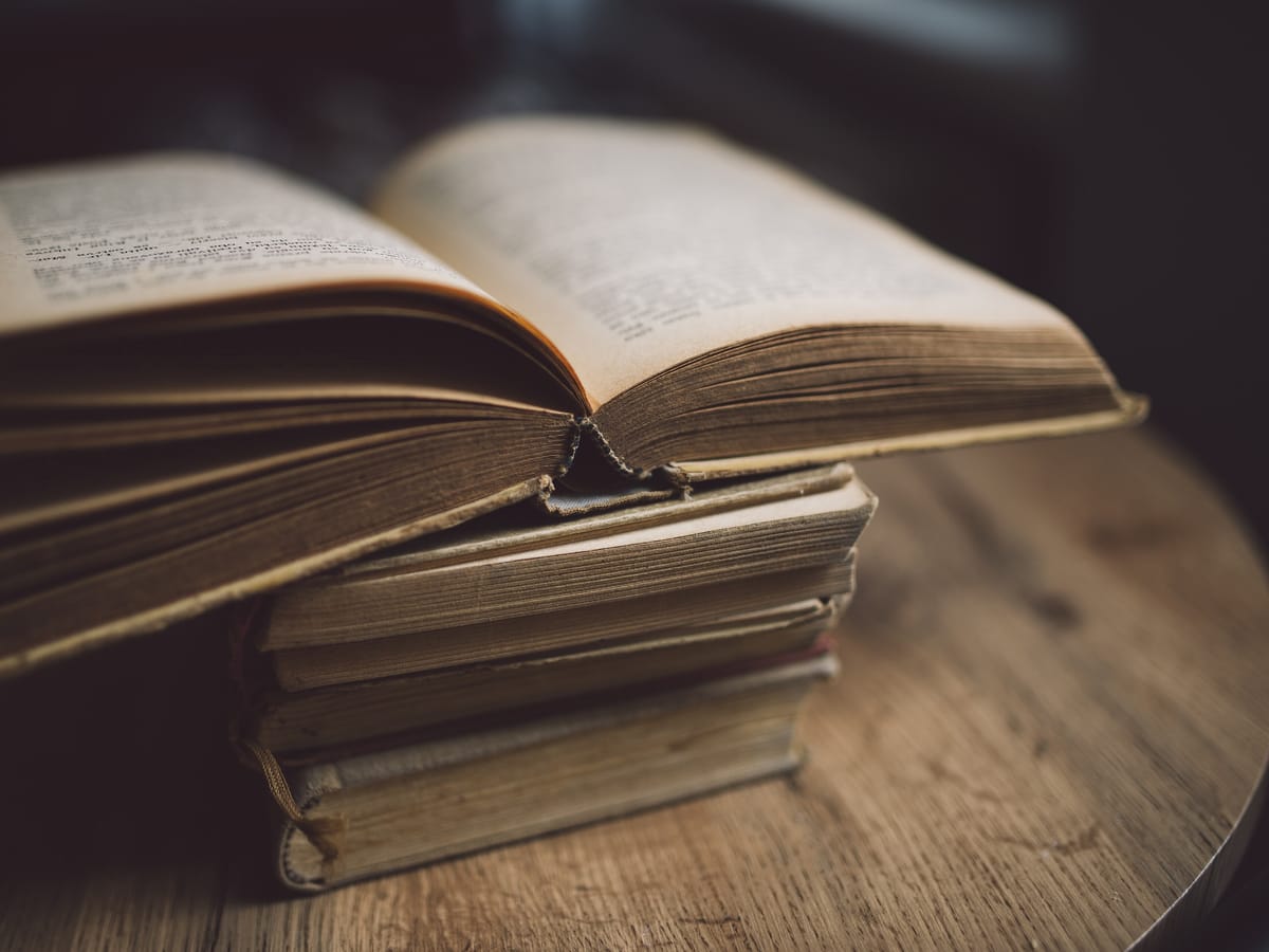 Sfeerbeeld: opengeslagen boeken op een houten tafel